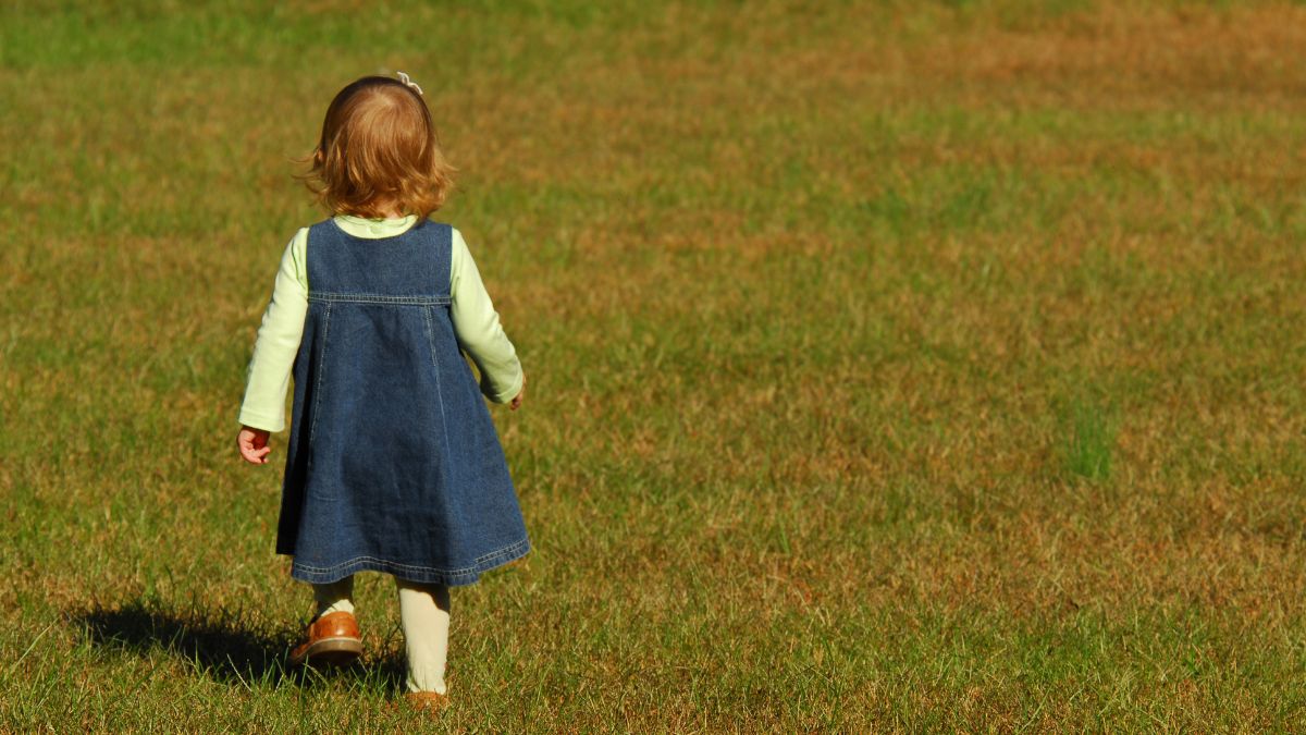 A young girl demonstrates elopement, or wanders away, in an open field